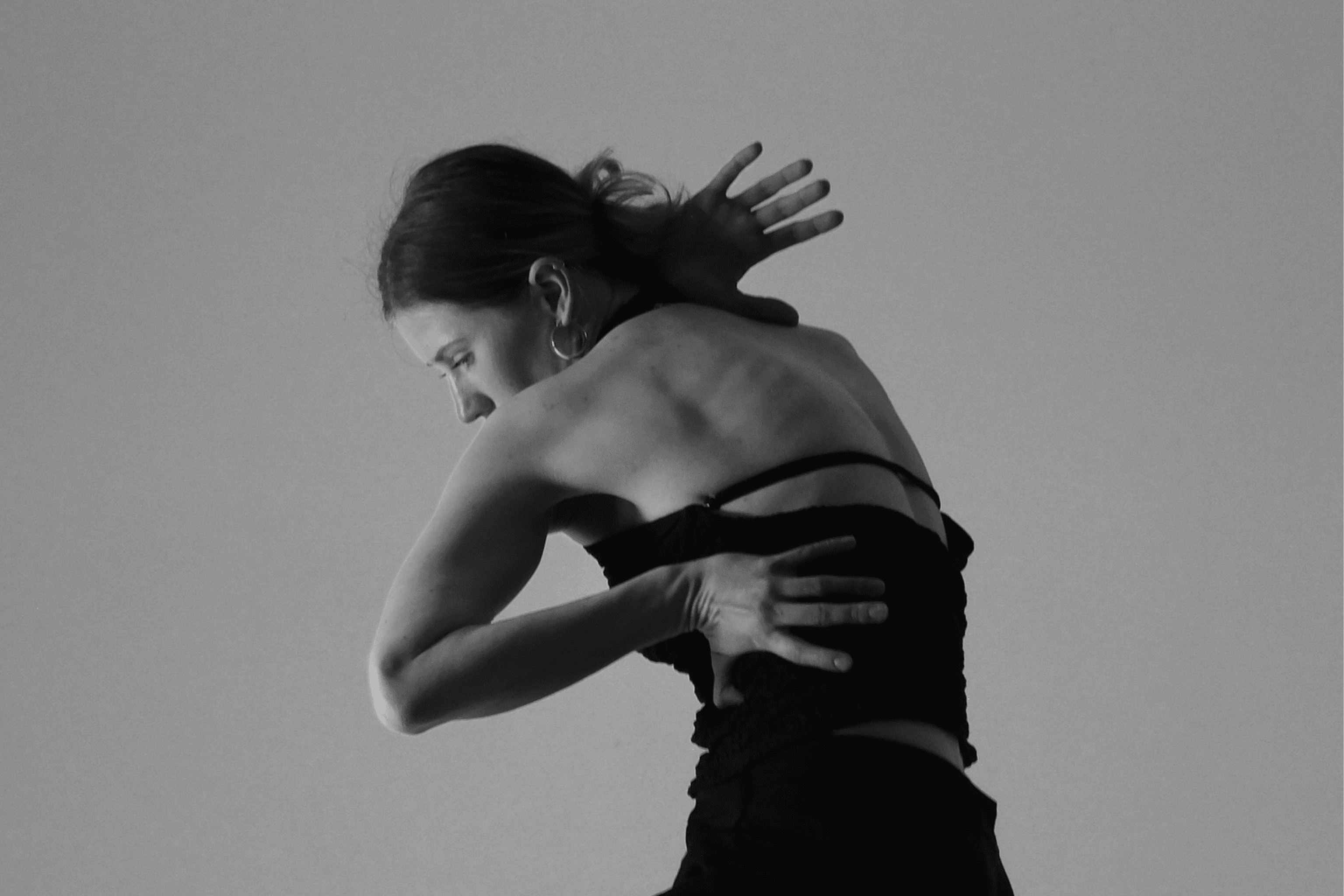 Black-and-white studio portrait of a dancer in motion